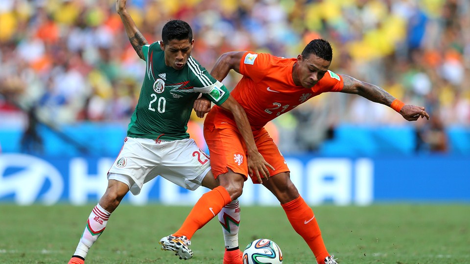 ممفیس دیپای - خاویِر آکینو|تقابل ممفیس دیپای از هلند با بازیکن مکزیک ، خاویِر آکینو برای گرفتن توپ.