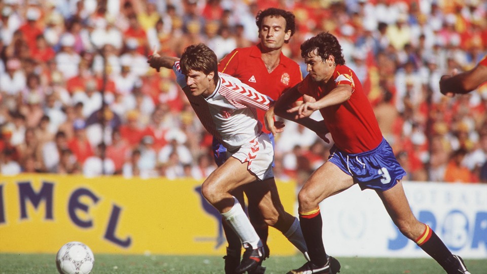 جام جهانی 1986|مایکل لادروپ از تیم دانمارک، از میان خوزه کاماچو و ریکاردو گالجو از تیم اسپانیا می گذرد. مرحله ی 16 تیم نهایی جام جهانی 1986 مکزیک. دانمارکی ها از روی پنالتی یک گل پیش می افتند اما اسپانیا با گلزنی امیلیو بوتراگوئنو در نهایت بازی را 5-1 به سود خود تمام می کنند.