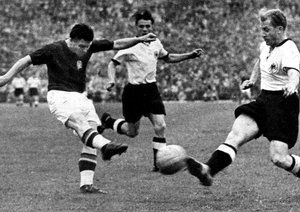 جام جهانی 1954|فینال جام جهانی 1954، برن، سوئیس، 4 جولای 1954. آلمان غربی 3-مجارستان 2، کاپیتان تیم ملی مجارستان، فرنس پوسکاس، حین ضربه زدن به توپ. ورنر لیبریش از تیم ملی آلمان تلاش می کند تا توپ را بلوکه کند.