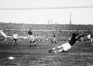 جام جهانی 1930|دروازه بان تیم ملی رومانی، یون لاپوسنینو، شیرجه می رود تا توپ را مهار کند. جام جهانی 1930، دیدار دو تیم اروگوئه و رومانی در ورزشگاه سنتناریو در مونته ویدئو، 21 جولای 1930. اروگوئه 4-0 به پیروزی رسید.