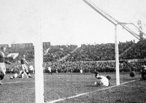 جام جهانی 1930|دروازه بان رومانی، یون لاپوسنینو دروازه اش توسط بازیکن تیم اروگوئه، پابلو دورادو (خارج از عکس) برای نخستین بار در جام جهانی باز میشود. دیدار دو تیم اروگوئه و رومانی در ورزشگاه سنتناریو در مونته ویدئو، 21 جولای 1930. اروگوئه 4-0 به پیروزی رسید.