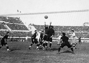 جام جهانی 1930|گیلرمو استابیل (سمت راست) از میان انبوه بازیکنان مکزیکی با سر به توپ ضربه می زند تا یک گل برای آرژانتین به ثمر برساند. دیدار آرژانتین و مکزیک در جام جهانی در ورزشگاه سنتناریو در مونته ویدئو، 19 جولای 1930. آرژانتین 6-3 به پیروزی رسید.