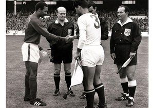 جام جهانی 1966|یک چهارم نهایی مسابقات جام جهانی 1966 انگلستان، گودیسون پارک، انگلستان، 23 جولای 1966، پرتغال 5-کره شمالی 3. کاپیتان پرتغال ماریو کولونا (چپ) پیش از شروع بازی با کاپیتان کره ی شمالی دست می دهد. یک شوک اصلی در این دیدار پیش افتادن 3-0 کره شمالی از پرتغال در نیمه اول بود، اما به یمن حضور اوزه بیو که چهار گل به ثمر رساند، پرتغال توانست در مجموع 5-3 به پیروزی دست یابد.