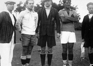 جام جهانی 1930|آنیبال تجدای داور (وسط) و کمک داوران ریکاردو والارینو و بالدوی در کنار کاپیتان برزیل، یائو کوئلیو نتو (ملقب به پرگوئینیو) و میلوتین ایوکویچ از تیم ملی یوگوسلاوی پیش از دیدار تیم های برزیل و یوگوسلاوی در سنترال پارک مونته ویدئو، 14 جولای 1930. یوگوسلاوی 2-1 به پیروزی رسید.