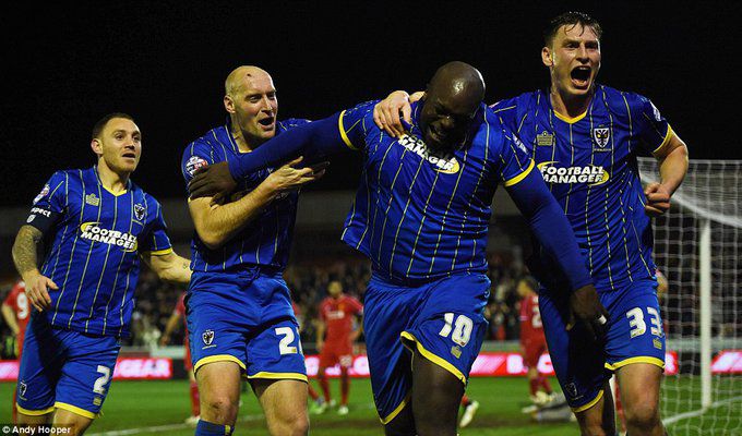 Akinfenwa (second from right) celebrates with his Wimbledon team-mates after equalising against their Premier Lea.jpg