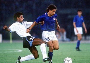 جام جهانی 1990|روبرتو باجو از ایتالیا تلاش می کند تا از روبن پریرا از اروگوئه در جریان دیدار تیمش در مرحله ی 16 تیم نهایی جام جهانی 1986، بگریزد. 25 ژوئن 1990. آتزوری به یمن گل های توتو شیلاچی و آلدو سرنا، 2-0 به پیروزی می رسد.