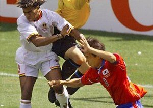 جام جهانی 1998|مهاجم بلژیکی، لوئیس اولیویرا (چپ) به هوا می پرد، زمانی که دروازه بان کره جنوبی، کیم بیونگ، مهار توپ را در دست می گیرد. گروه E جام جهانی 1998 فرانسه، 25 ژوئن، وزشگاه پارک دپرینس، پاریس.